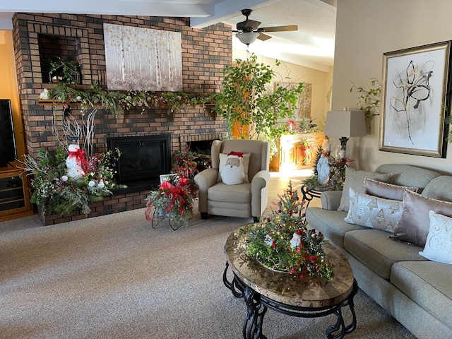 carpeted living room with a fireplace, vaulted ceiling with beams, and ceiling fan