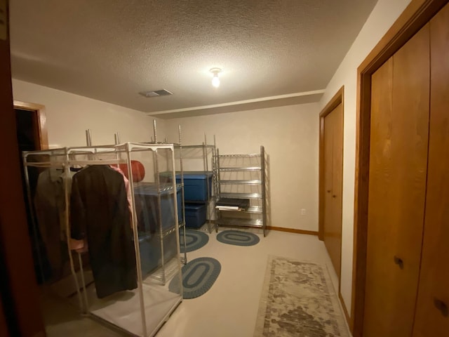 interior space featuring baseboards, visible vents, and a textured ceiling