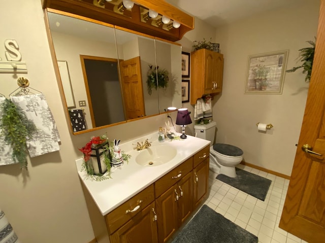 bathroom featuring toilet, baseboards, and vanity