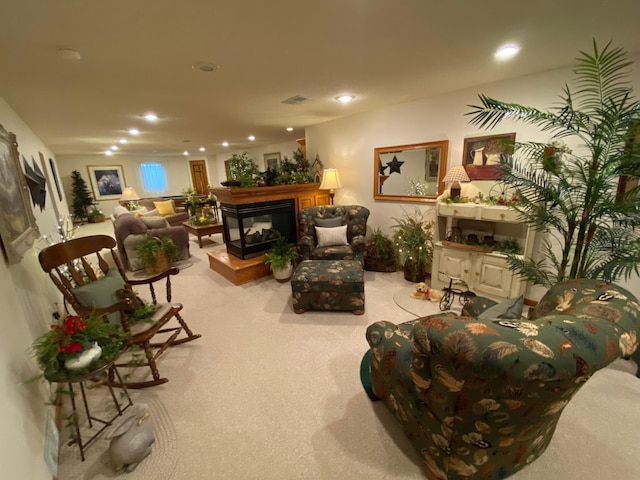 carpeted living area with a multi sided fireplace, visible vents, and recessed lighting