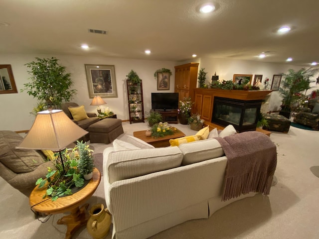 living room with carpet flooring, a glass covered fireplace, visible vents, and recessed lighting