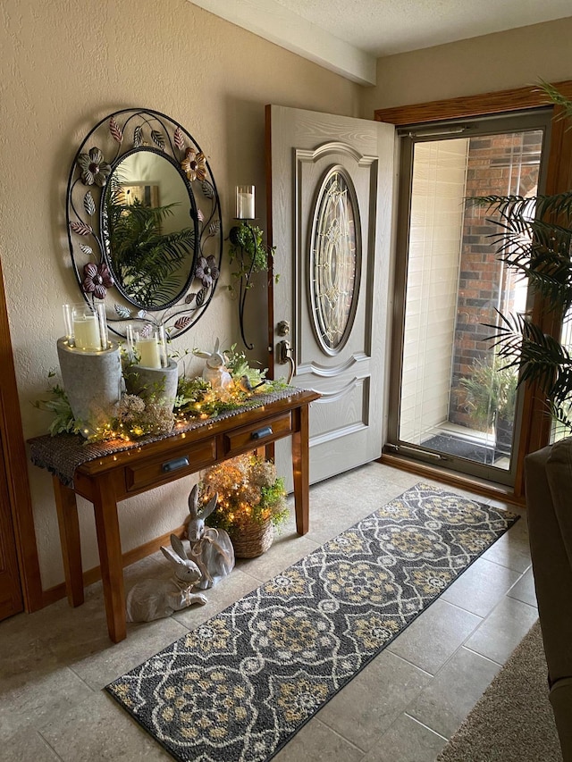 foyer featuring a textured ceiling and a textured wall