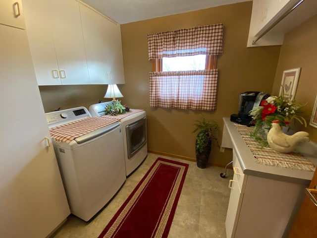 laundry room with washer and clothes dryer, cabinet space, and baseboards