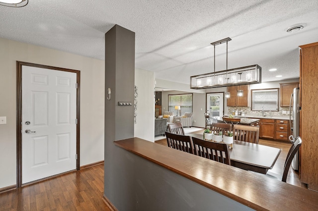 dining room featuring dark hardwood / wood-style floors and a textured ceiling