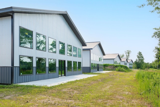 back of property featuring a lawn and a patio area