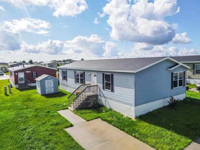 view of front of house with a front lawn and a storage unit