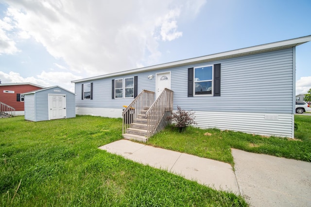 view of front of house with a front lawn and a storage shed