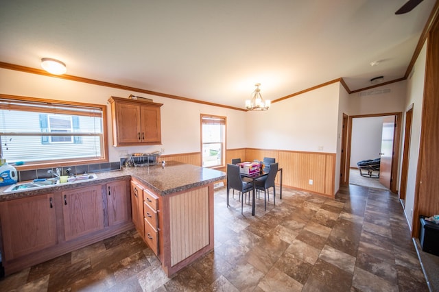 kitchen with dark tile patterned flooring, sink, plenty of natural light, and kitchen peninsula