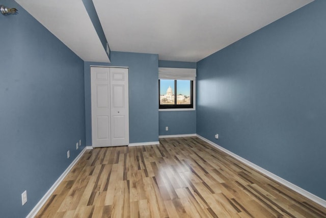 unfurnished bedroom with light hardwood / wood-style floors and a closet