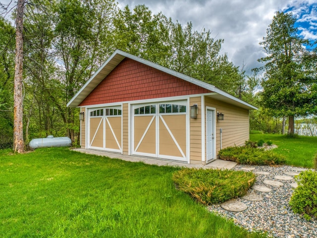 view of outdoor structure featuring a garage and a lawn