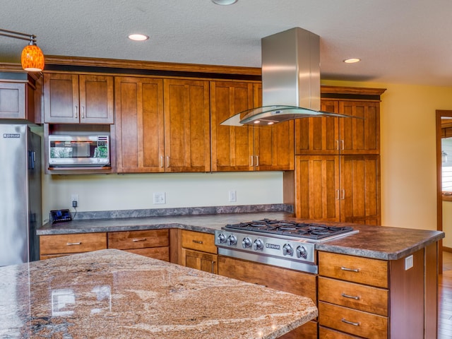 kitchen with island range hood, dark stone countertops, stainless steel appliances, and a textured ceiling