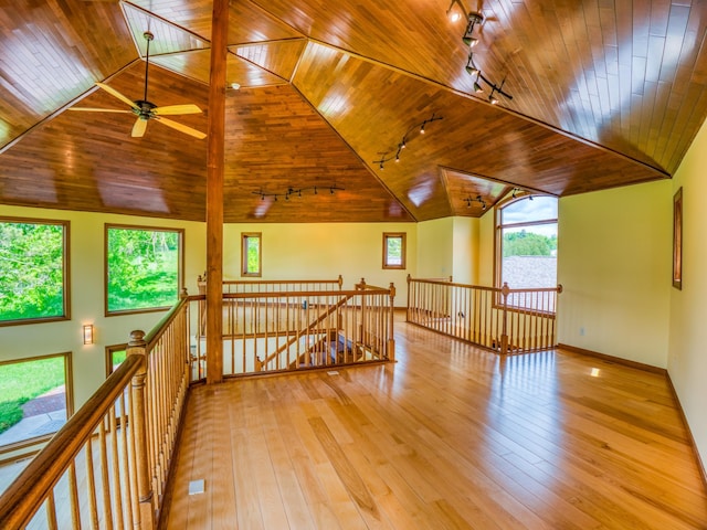 spare room with a wealth of natural light, wood ceiling, and light hardwood / wood-style flooring