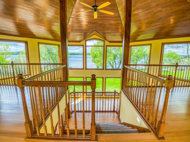 sunroom featuring a water view, lofted ceiling, and wooden ceiling