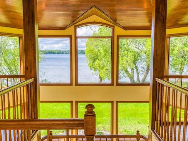 sunroom with a water view, vaulted ceiling, and wooden ceiling