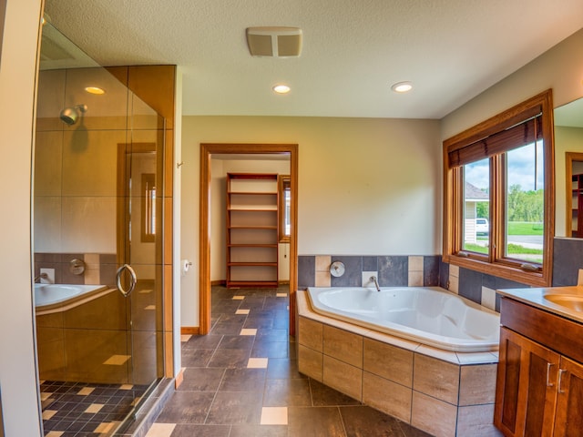 bathroom featuring vanity, plus walk in shower, and a textured ceiling