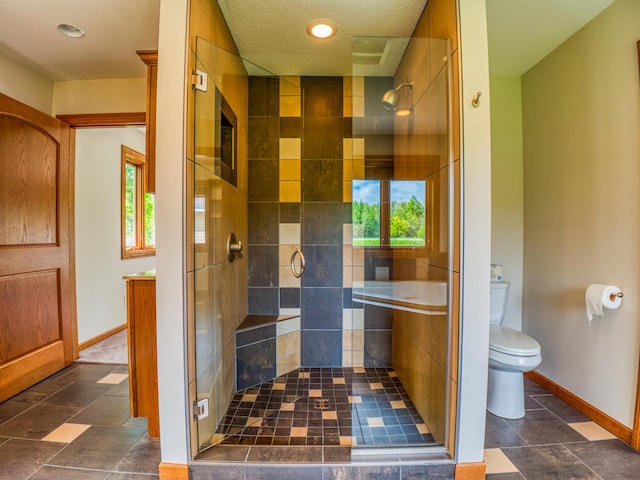 bathroom with toilet, a textured ceiling, and an enclosed shower