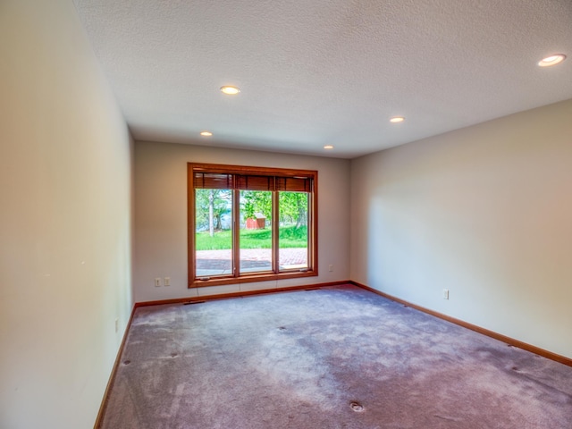 empty room featuring a textured ceiling and carpet flooring