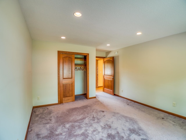 unfurnished bedroom with a closet and light colored carpet