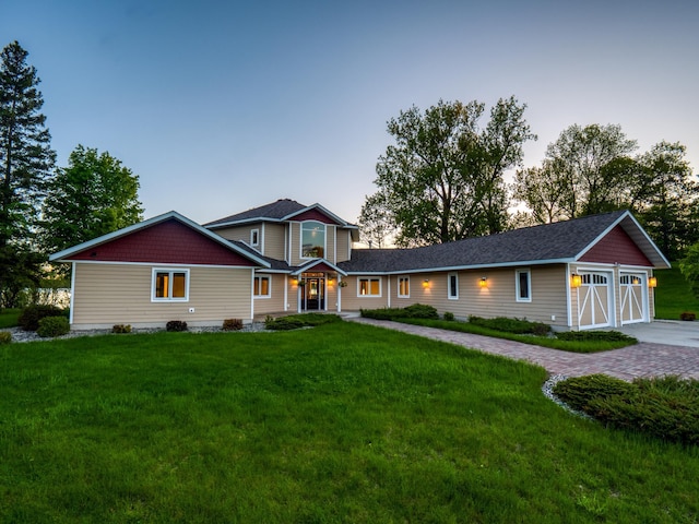 view of front of house with a garage and a yard