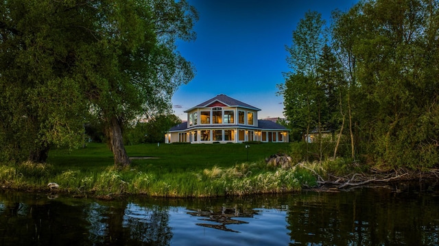 back of house featuring a water view and a yard