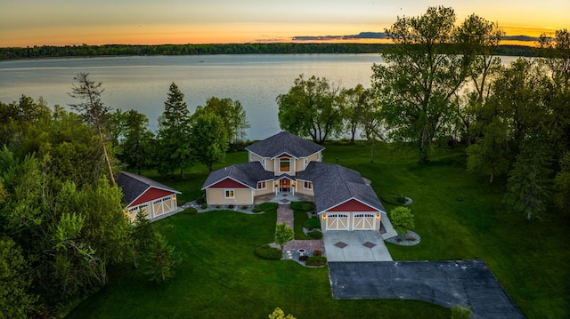 aerial view at dusk featuring a water view