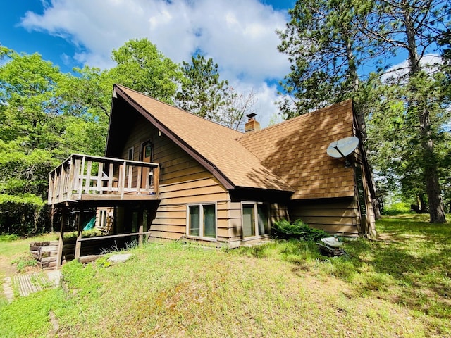 back of house featuring a lawn and a deck