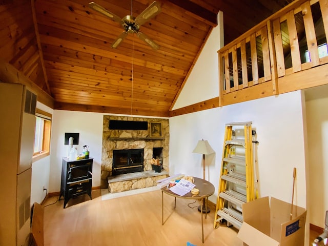 living room featuring light hardwood / wood-style flooring, vaulted ceiling, wooden ceiling, and a fireplace