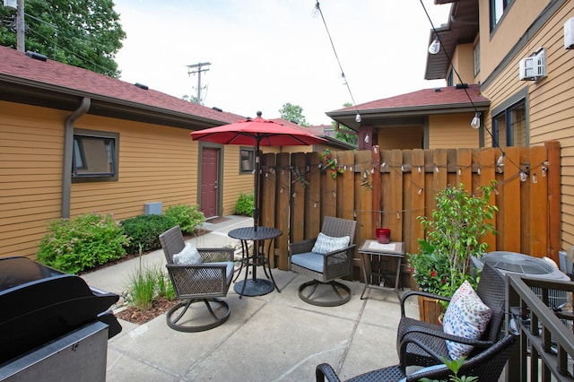 view of patio with a grill and an AC wall unit