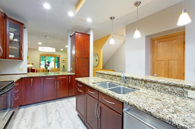 kitchen with pendant lighting, sink, light hardwood / wood-style flooring, appliances with stainless steel finishes, and light stone counters