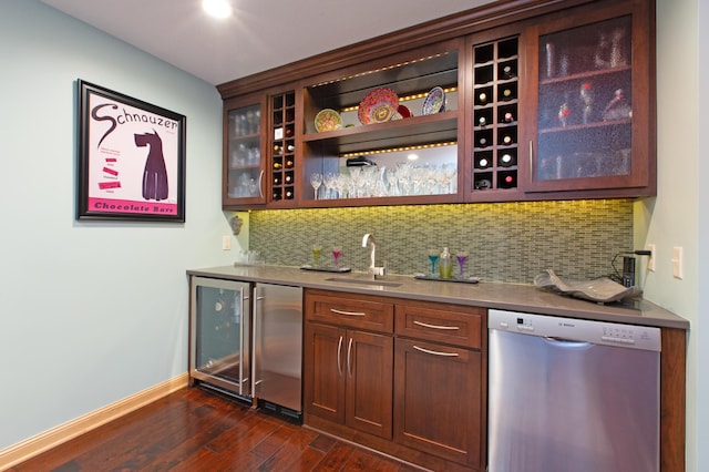 bar featuring tasteful backsplash, sink, stainless steel dishwasher, and dark hardwood / wood-style flooring