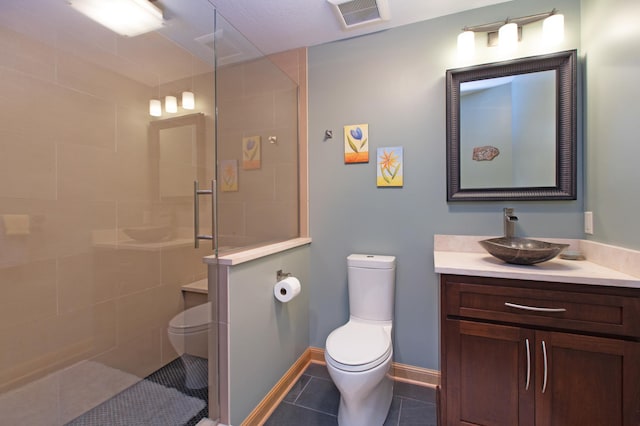 bathroom with an enclosed shower, vanity, tile patterned flooring, and toilet