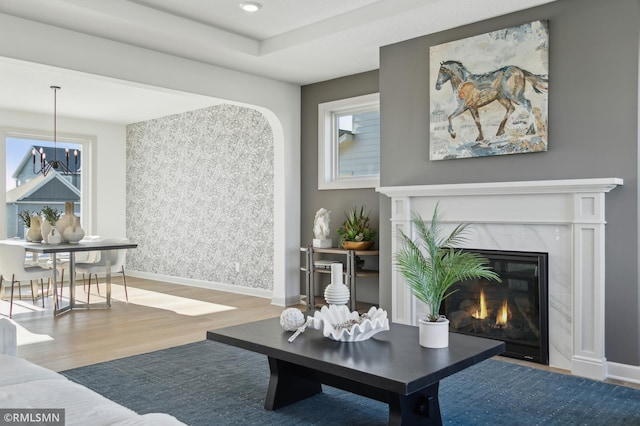 living room with wood-type flooring and a high end fireplace