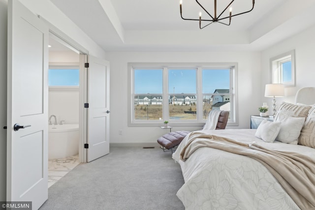 bedroom with light carpet, a notable chandelier, and a tray ceiling