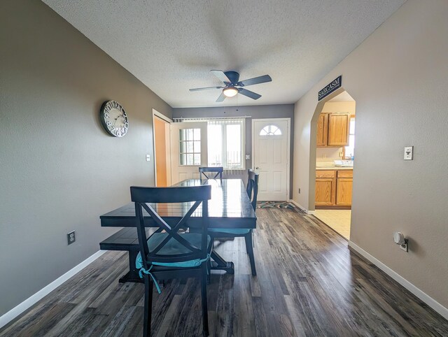 dining area with a textured ceiling, ceiling fan, and dark hardwood / wood-style floors