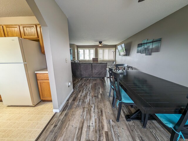 dining space featuring hardwood / wood-style flooring, ceiling fan, and a textured ceiling