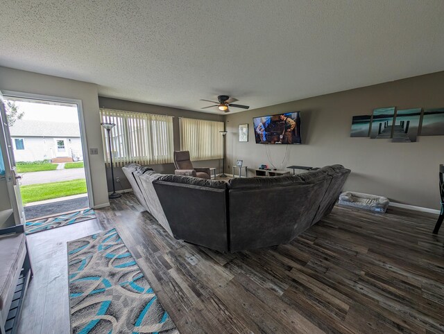 living room featuring a textured ceiling, ceiling fan, and dark hardwood / wood-style flooring