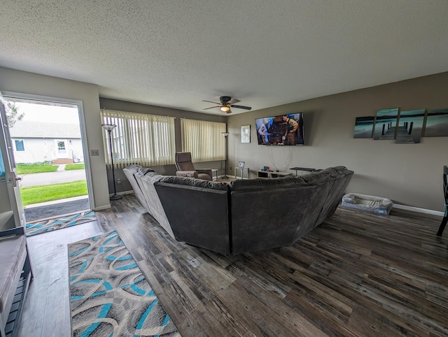 living area featuring ceiling fan, a textured ceiling, baseboards, and wood finished floors