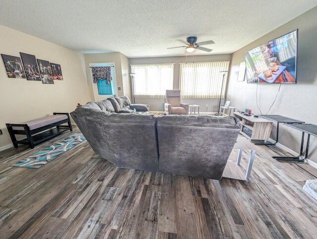 living room with ceiling fan, a textured ceiling, and hardwood / wood-style flooring