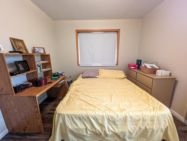 bedroom with a textured ceiling and dark hardwood / wood-style floors