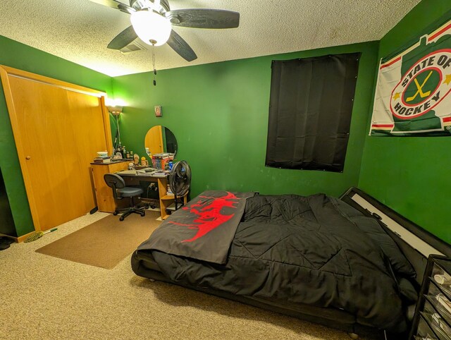 carpeted bedroom featuring ceiling fan and a textured ceiling