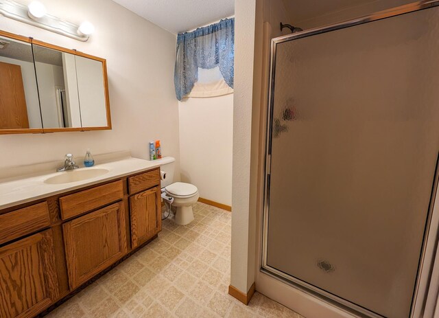 bathroom featuring a shower with shower door, vanity, toilet, and tile floors