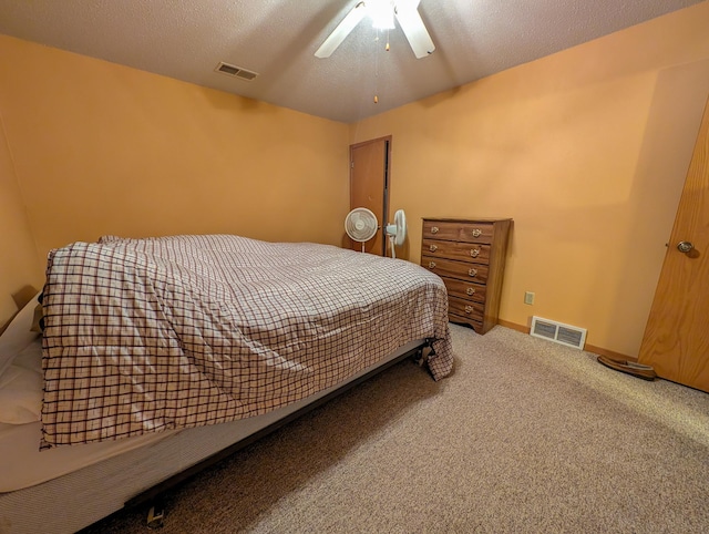 bedroom featuring carpet, visible vents, and a textured ceiling