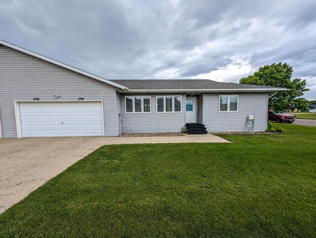 ranch-style house featuring a garage and a front lawn