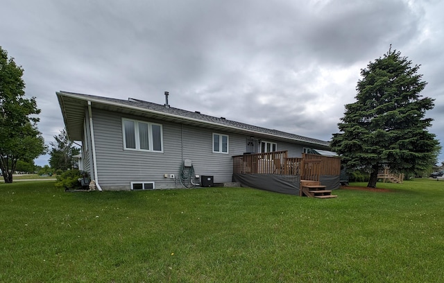 rear view of house featuring a deck, central AC, and a lawn