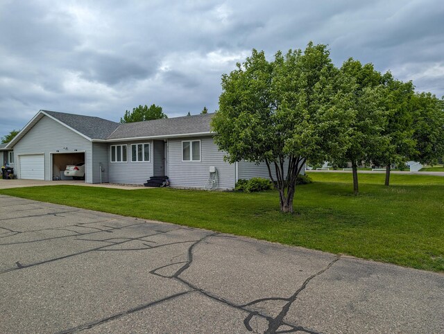 ranch-style home featuring a garage and a front lawn