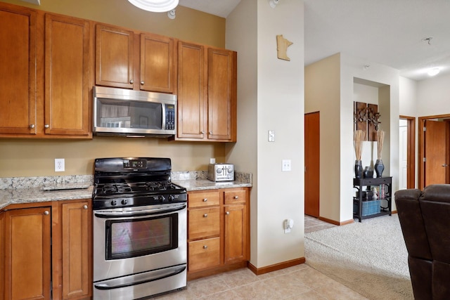 kitchen featuring light stone counters, light tile patterned floors, and appliances with stainless steel finishes