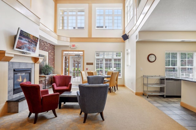 living room with a towering ceiling, a fireplace, and light tile patterned floors