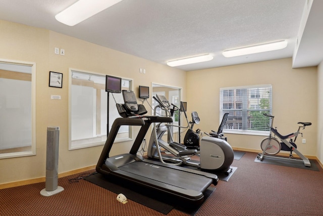 gym featuring carpet floors and a textured ceiling