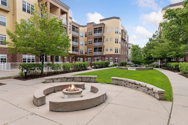 view of community with a fire pit and a yard