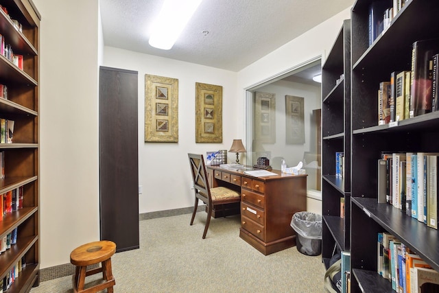 carpeted office featuring a textured ceiling